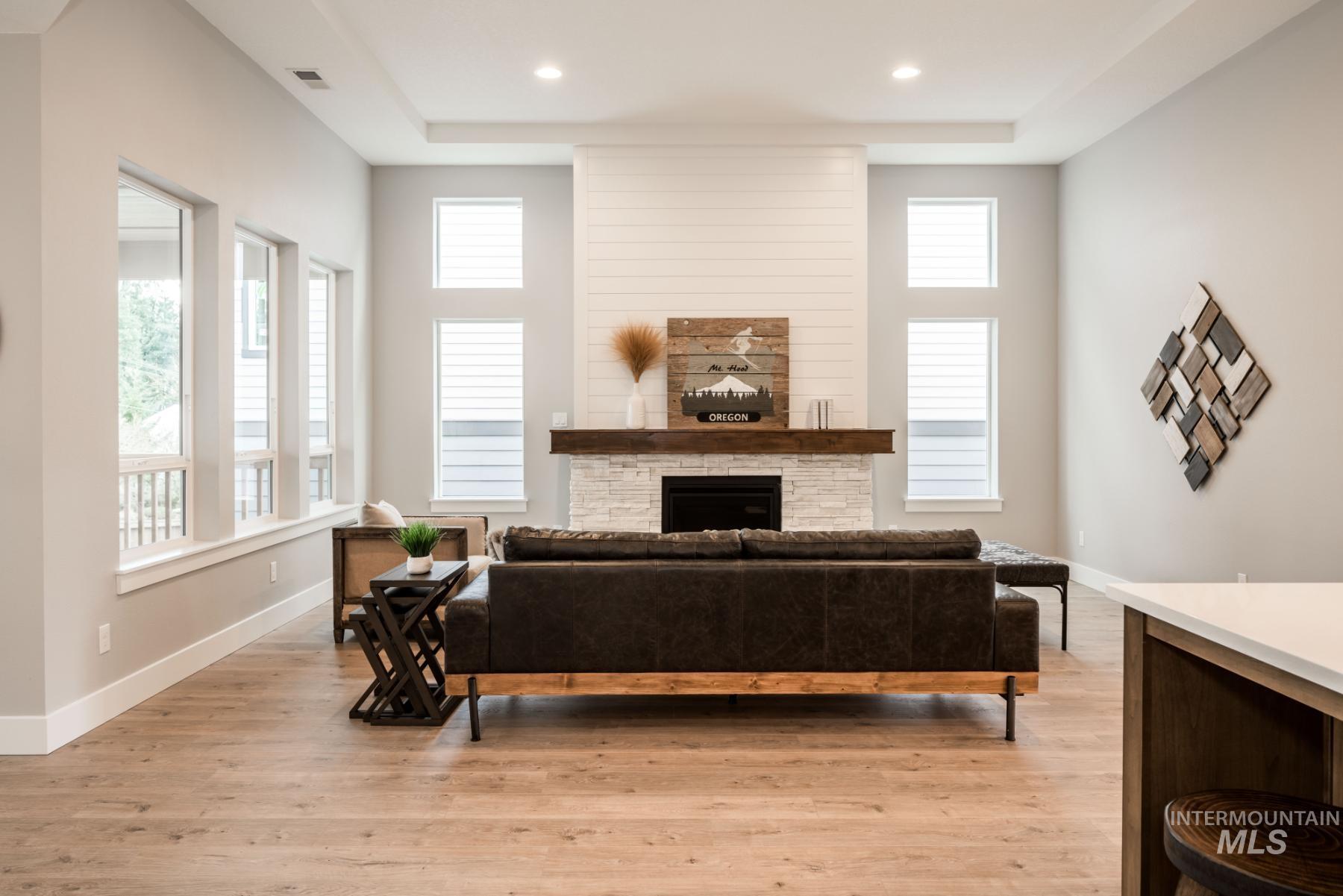 1279 West Malbar Street Meridian, ID 83646 - Photo 14 of 23 Living area with a stone fireplace and light wood-style flooring