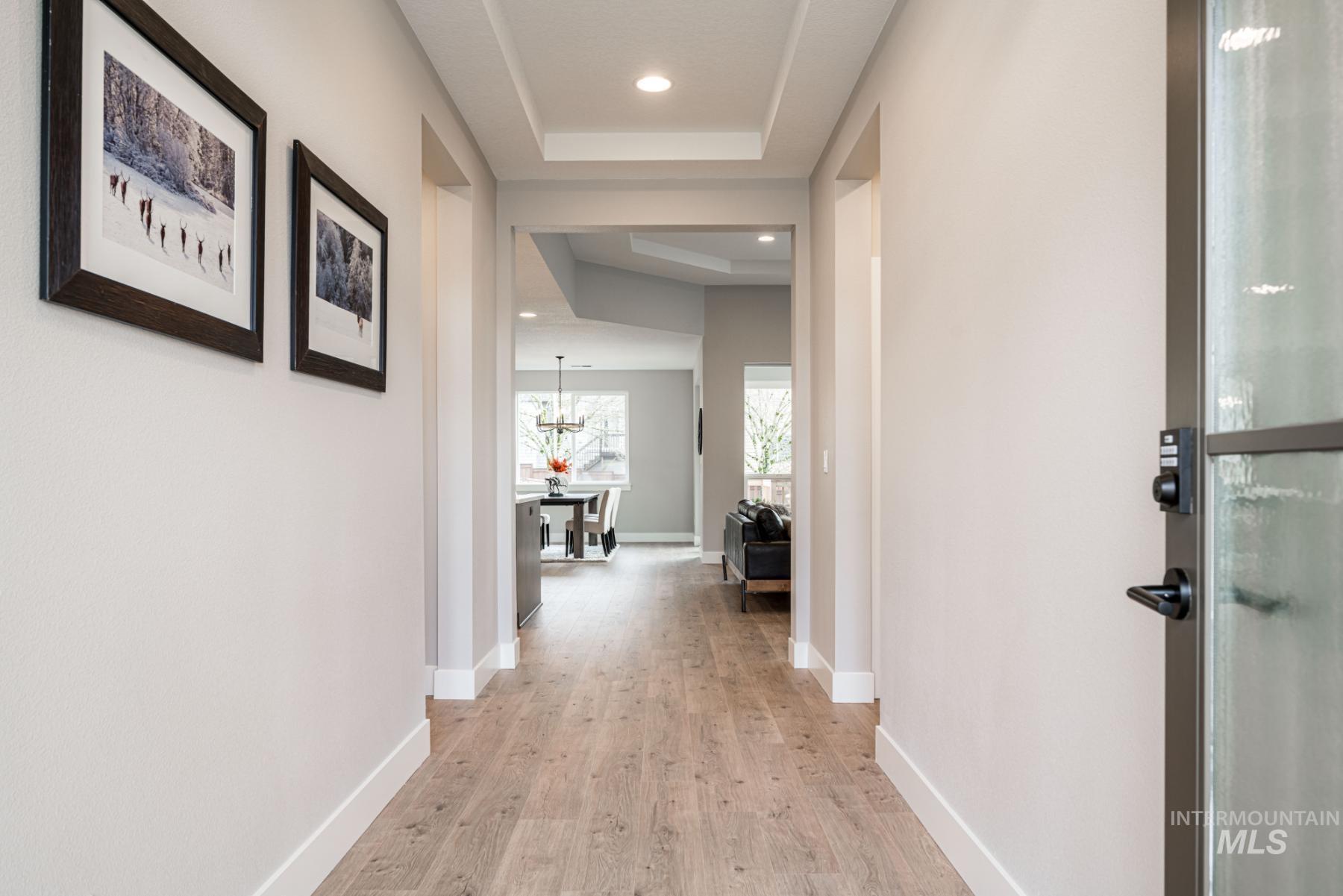 1279 West Malbar Street Meridian, ID 83646 - Photo 2 of 23 Hall with a raised ceiling, light wood-style floors, recessed lighting, and a chandelier