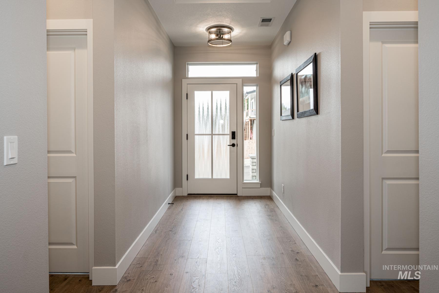 1279 West Malbar Street Meridian, ID 83646 - Photo 3 of 23 Doorway with wood finished floors and a textured wall