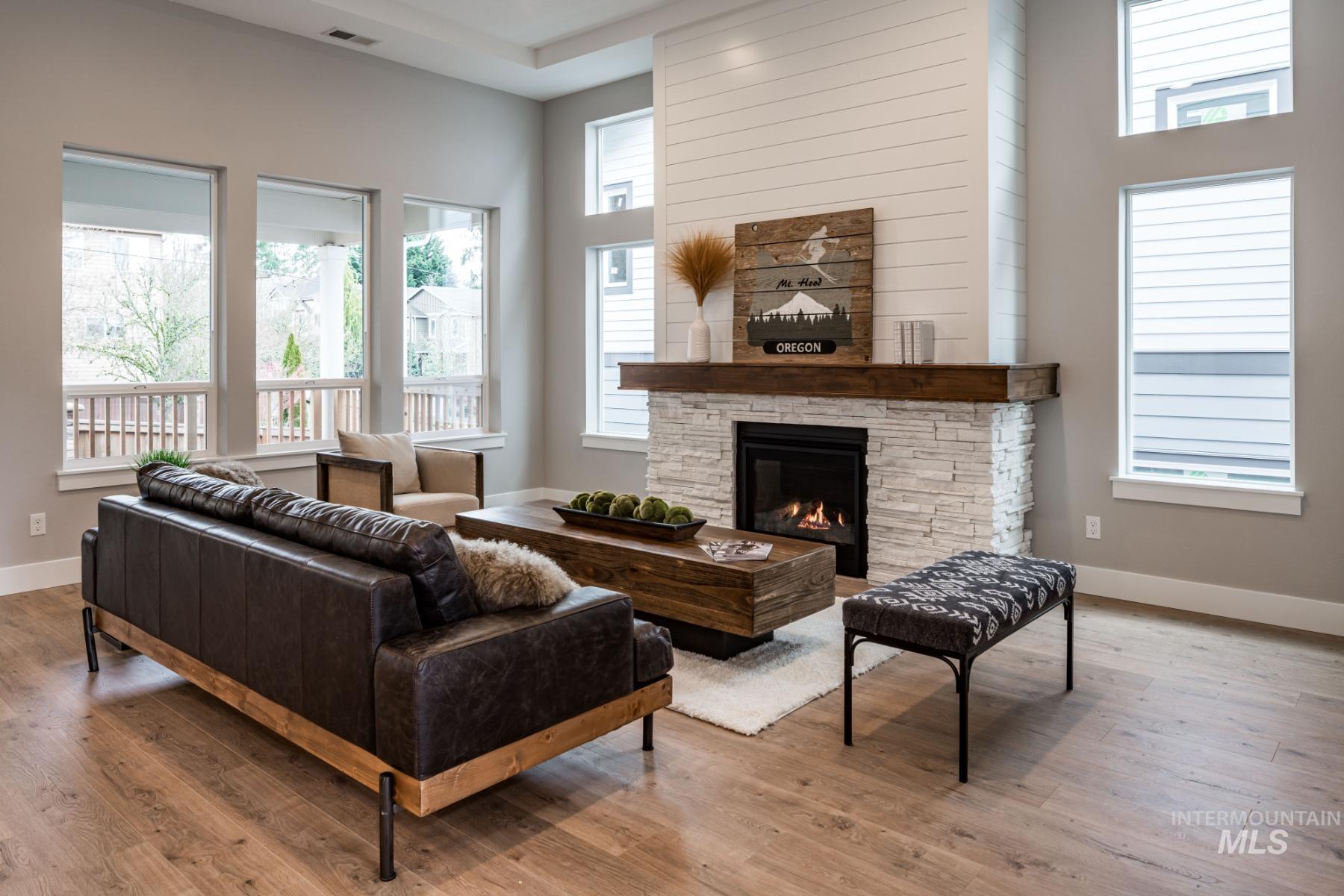 1279 West Malbar Street Meridian, ID 83646 - Photo 6 of 23 Living area with a fireplace, wood finished floors, and a high ceiling