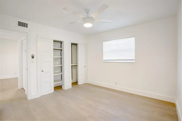 an empty room with closet and windows