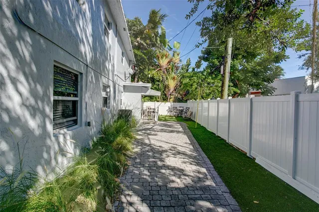 a view of a pathway of house with wooden fence