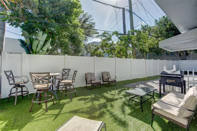 a view of a patio with table and chairs under an umbrella