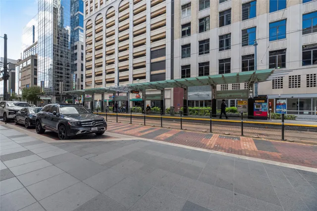 a black leather couch sitting in a living room next to a lamp