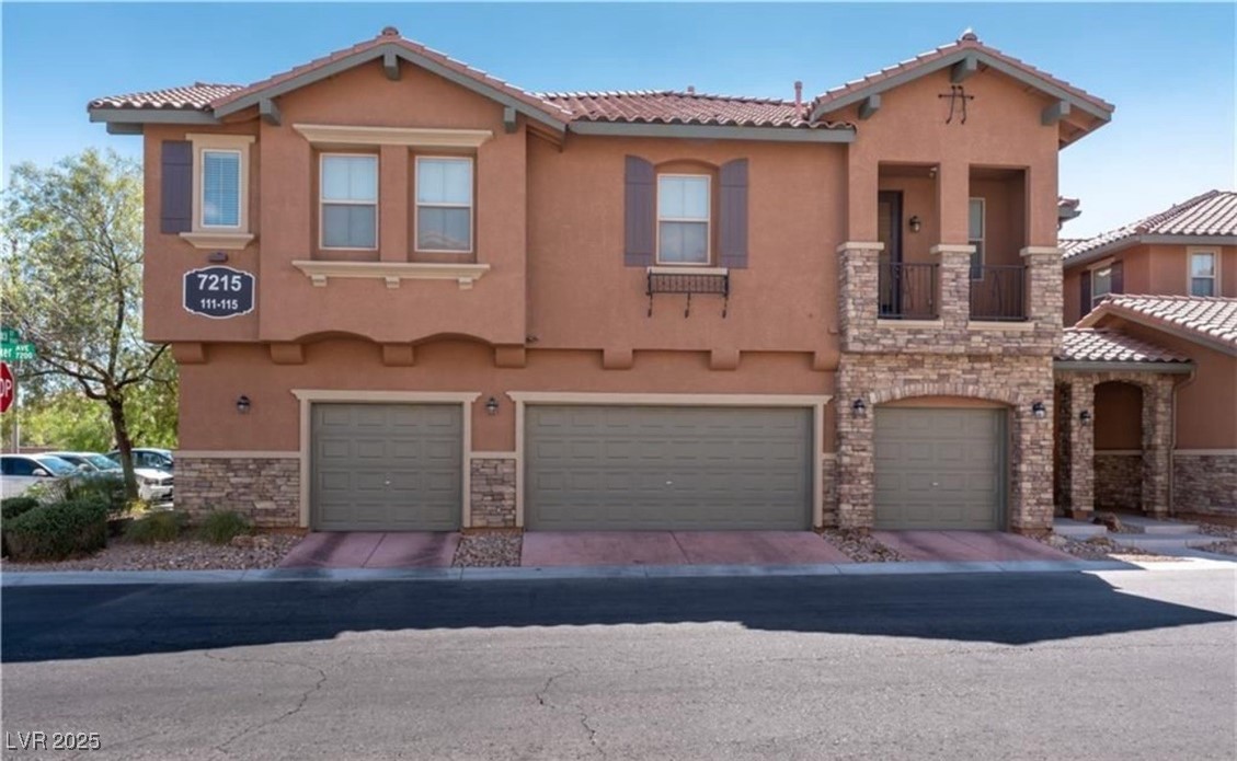 Mediterranean / spanish home featuring a balcony, stone siding, stucco siding, and an attached garage