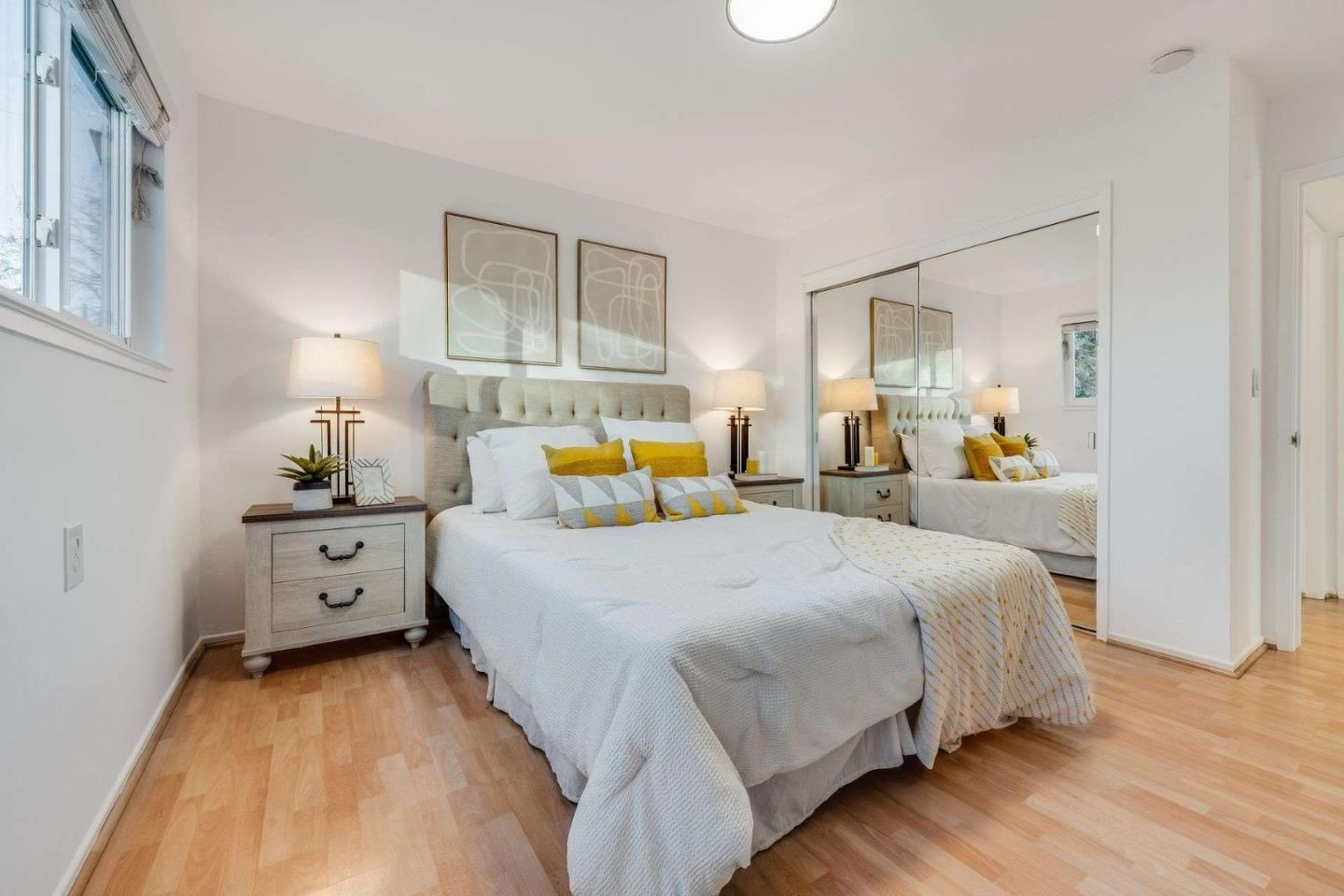 14225 Lora Drive, Unit 59 Los Gatos, CA 95032 - Photo 13 of 20 a bedroom with a large bed and a lamp on dresser with wooden floor