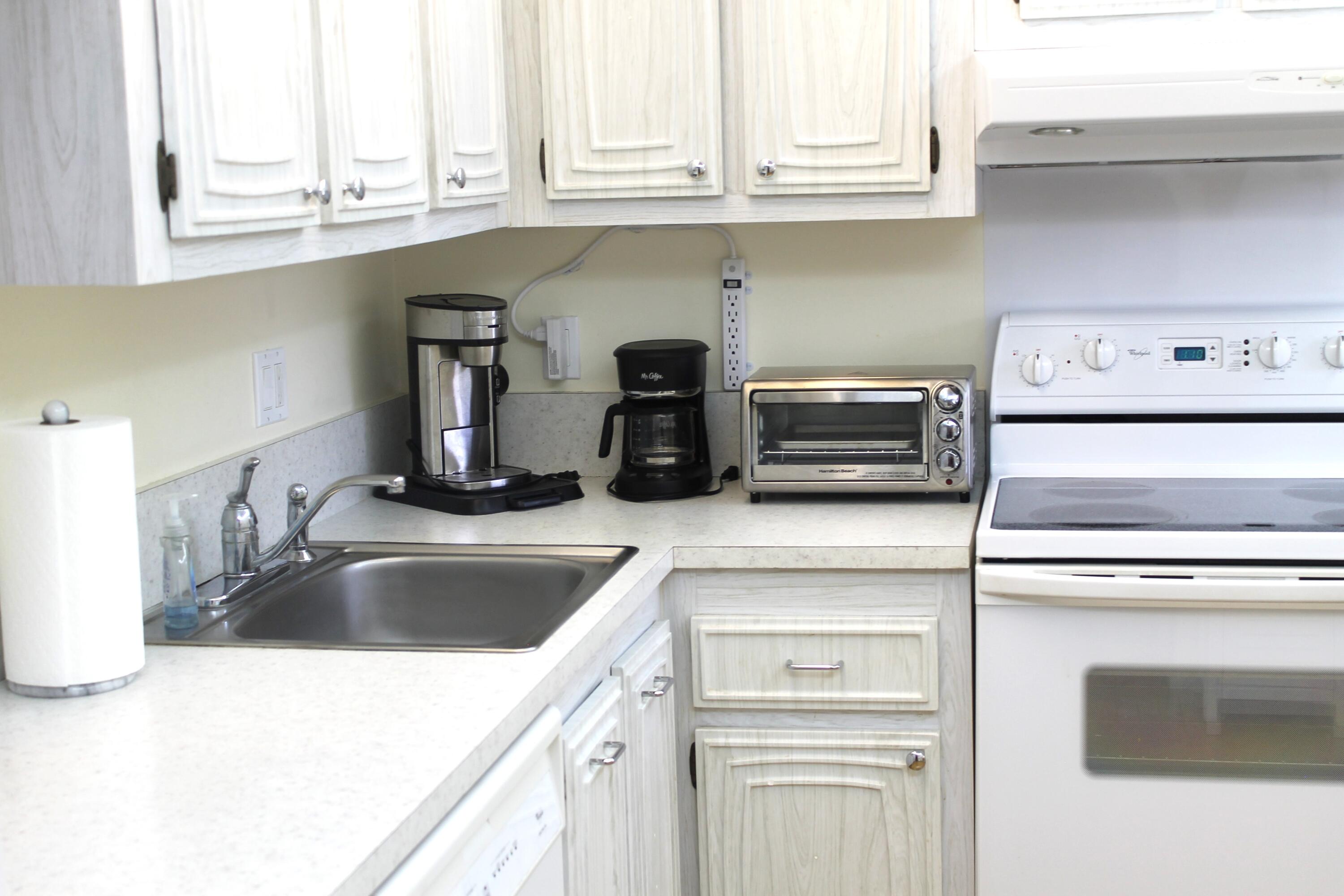 6461 Northwest 2nd Avenue, Unit 102 Boca Raton, FL 33487 - Photo 15 of 30 a kitchen with granite countertop a sink and a stove