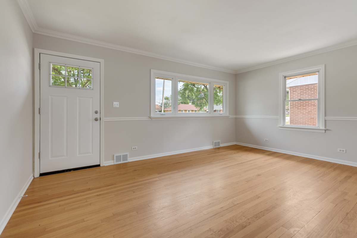 1528 Herbert Avenue Berkeley, IL 60163 - Photo 3 of 25 a view of an empty room with wooden floor and a window