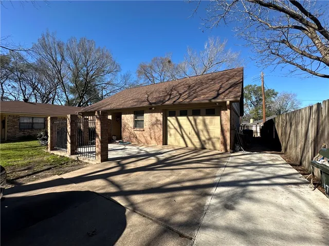 a view of a house with a patio and a yard