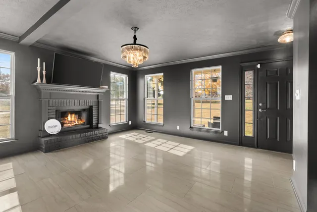 a view of a livingroom with a chandelier fan and a large window