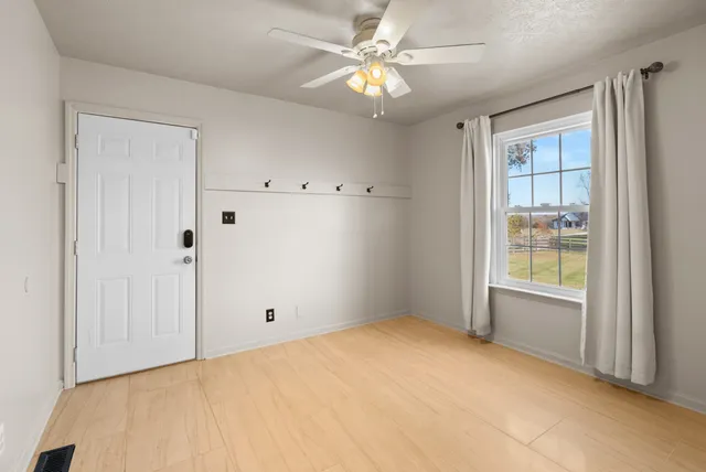 a bedroom with a large bed and chandelier fan