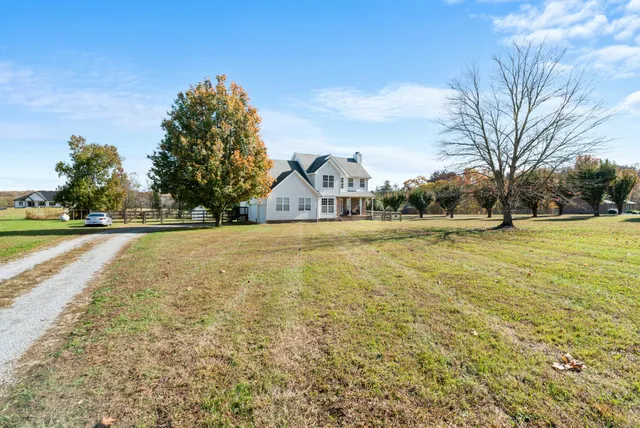 a front view of a house with a yard and trees