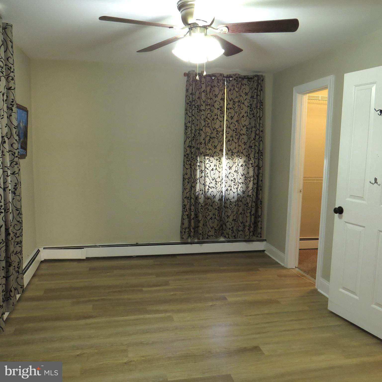 4930 Ridge Road Rosedale, MD 21237 - Photo 13 of 49 an empty room with wooden floor fan and windows