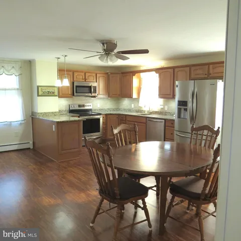 a kitchen with kitchen island granite countertop a sink and refrigerator