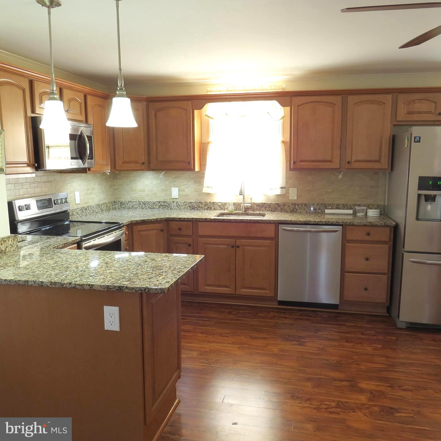 4930 Ridge Road Rosedale, MD 21237 - Photo 9 of 49 a kitchen with granite countertop stainless steel appliances a sink a counter space and a window