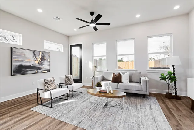 a living room with furniture a flat screen tv and a table