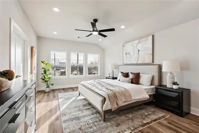 a bedroom with a bed a mirror and a large window