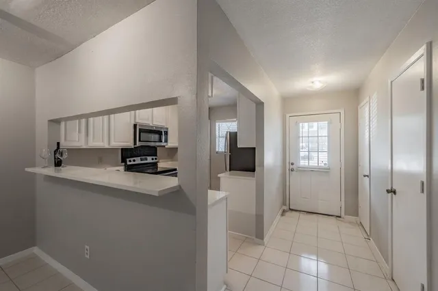 a view of a kitchen with a sink and a refrigerator