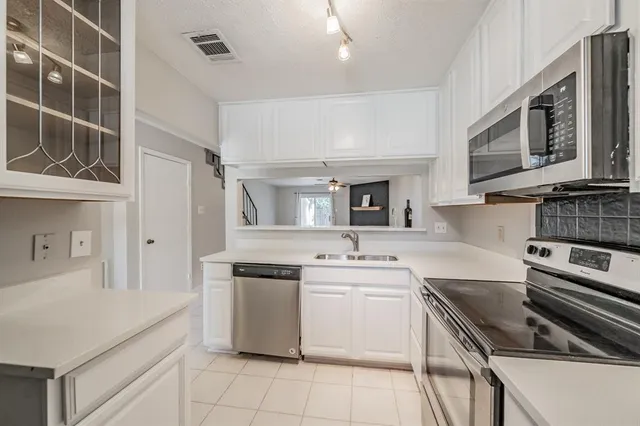 a kitchen with stainless steel appliances a stove microwave and sink