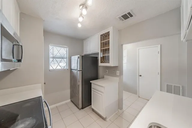 a kitchen with stainless steel appliances a refrigerator and a stove top oven