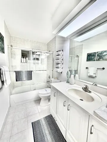 a spacious bathroom with a double vanity sink a mirror and a bathtub