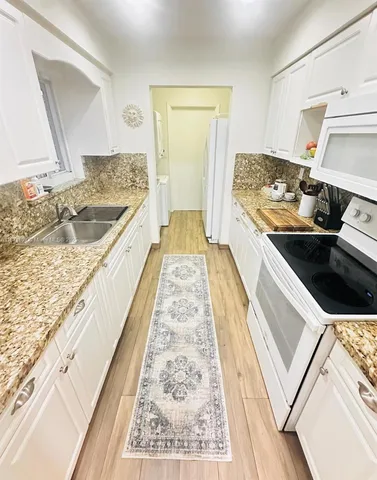 a kitchen with a sink stove and refrigerator