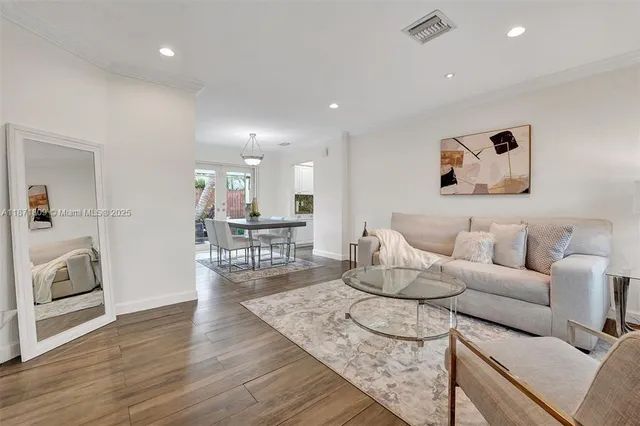 a living room with furniture and a wooden floor