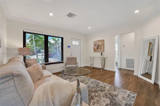 a living room with furniture large window and wooden floor