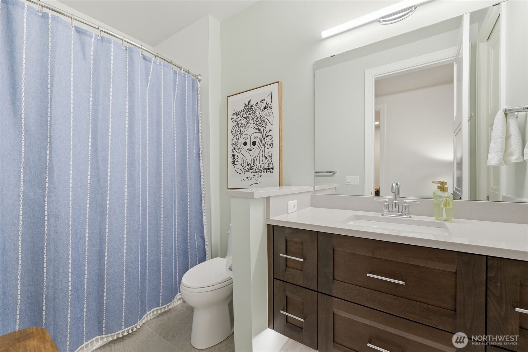 4907 Main Street, Unit 102 Tacoma, WA 98407 - Photo 20 of 34 a bathroom with a toilet a sink and a large mirror