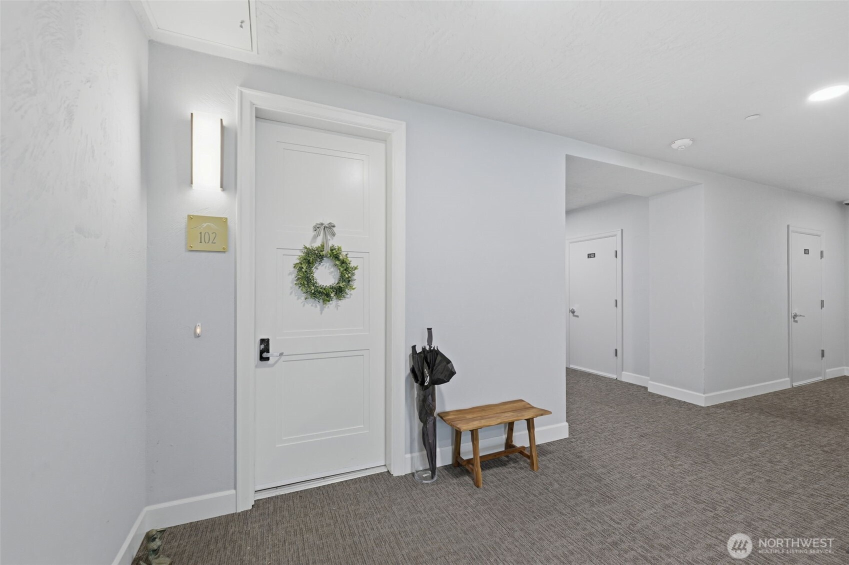4907 Main Street, Unit 102 Tacoma, WA 98407 - Photo 25 of 34 a view of a hallway that has a bench and a potted plant