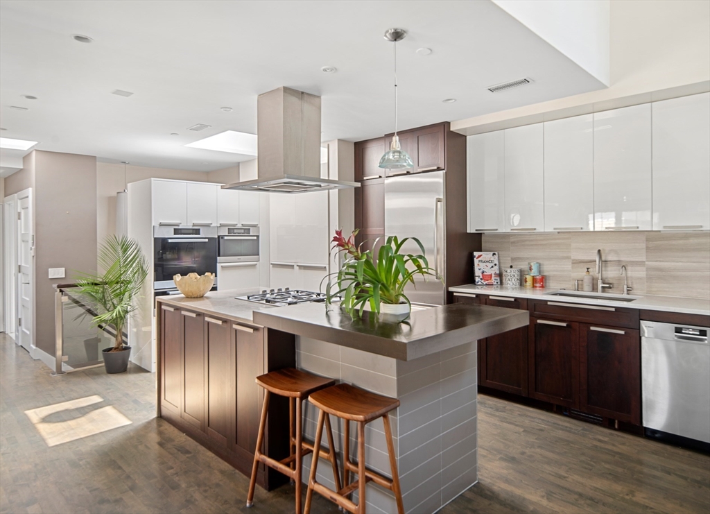85 Sherman Street, Unit 10 Cambridge, MA 02140 - Photo 3 of 21 a kitchen with kitchen island granite countertop a sink stove and refrigerator