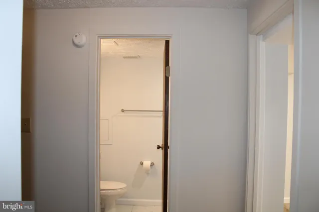 a bathroom with a granite countertop toilet and a shower