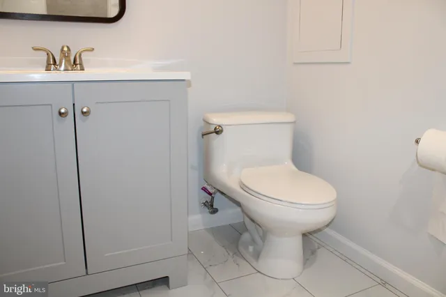 a bathroom with a toilet sink and a mirror
