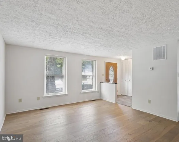 an empty room with windows and closet