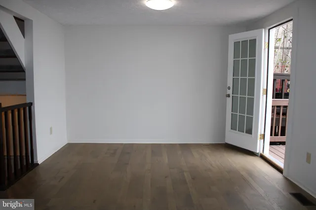 an empty room with wooden floor and a window