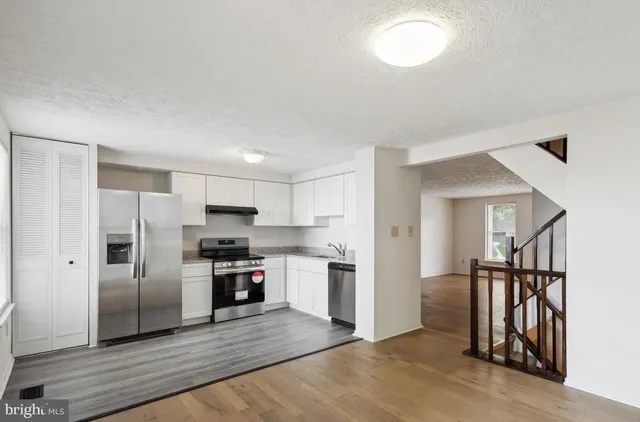 a kitchen with stainless steel appliances granite countertop a refrigerator and a stove top oven