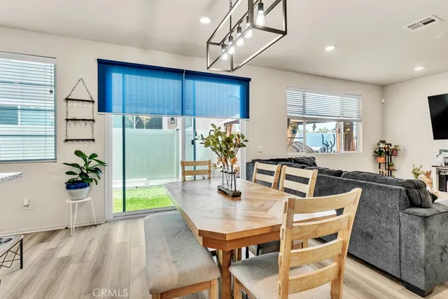 a dining room with furniture potted plants and wooden floor