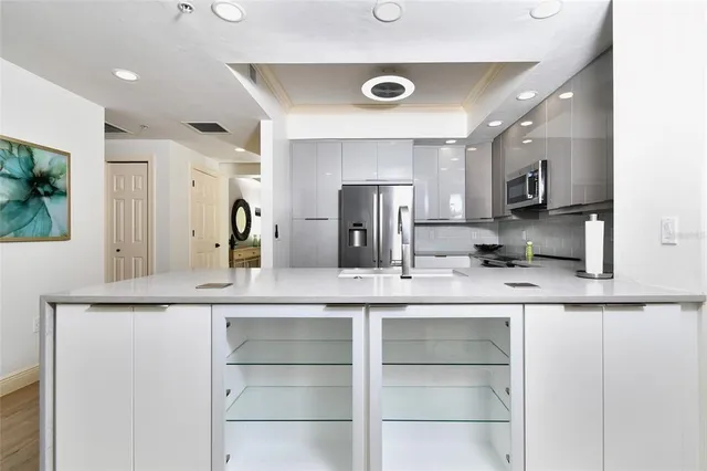 a kitchen with a sink a counter space appliances and cabinets