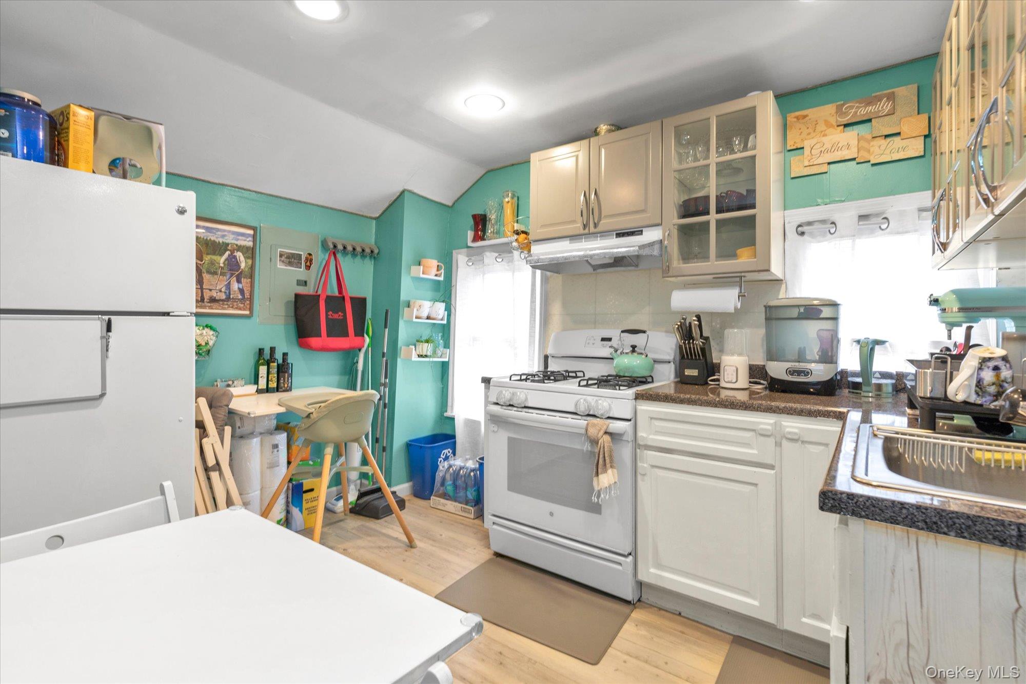 218-12 141st Road Queens, NY 11413 - Photo 16 of 21 a kitchen with stainless steel appliances white cabinets and wooden floor