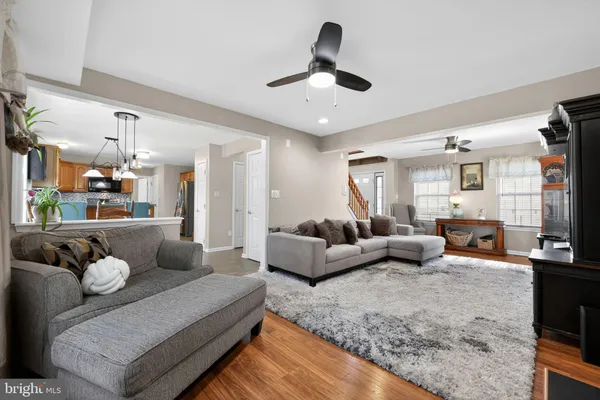 a living room with furniture kitchen view and a chandelier