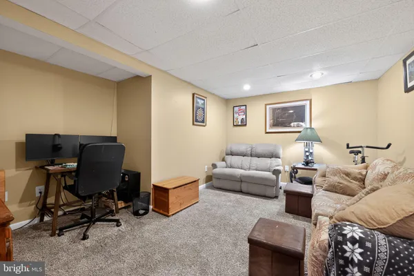 a living room with furniture and a air conditioner vent