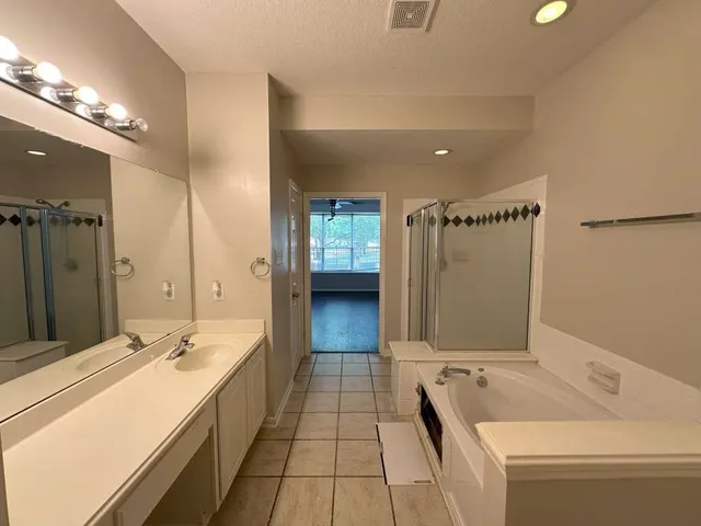 a bathroom with a tub sink and mirror