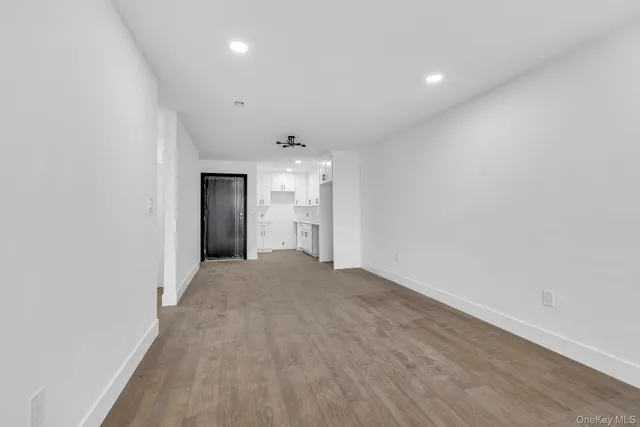 a view of a hallway with wooden floor and a window