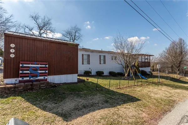 a view of a house with backyard and sitting area