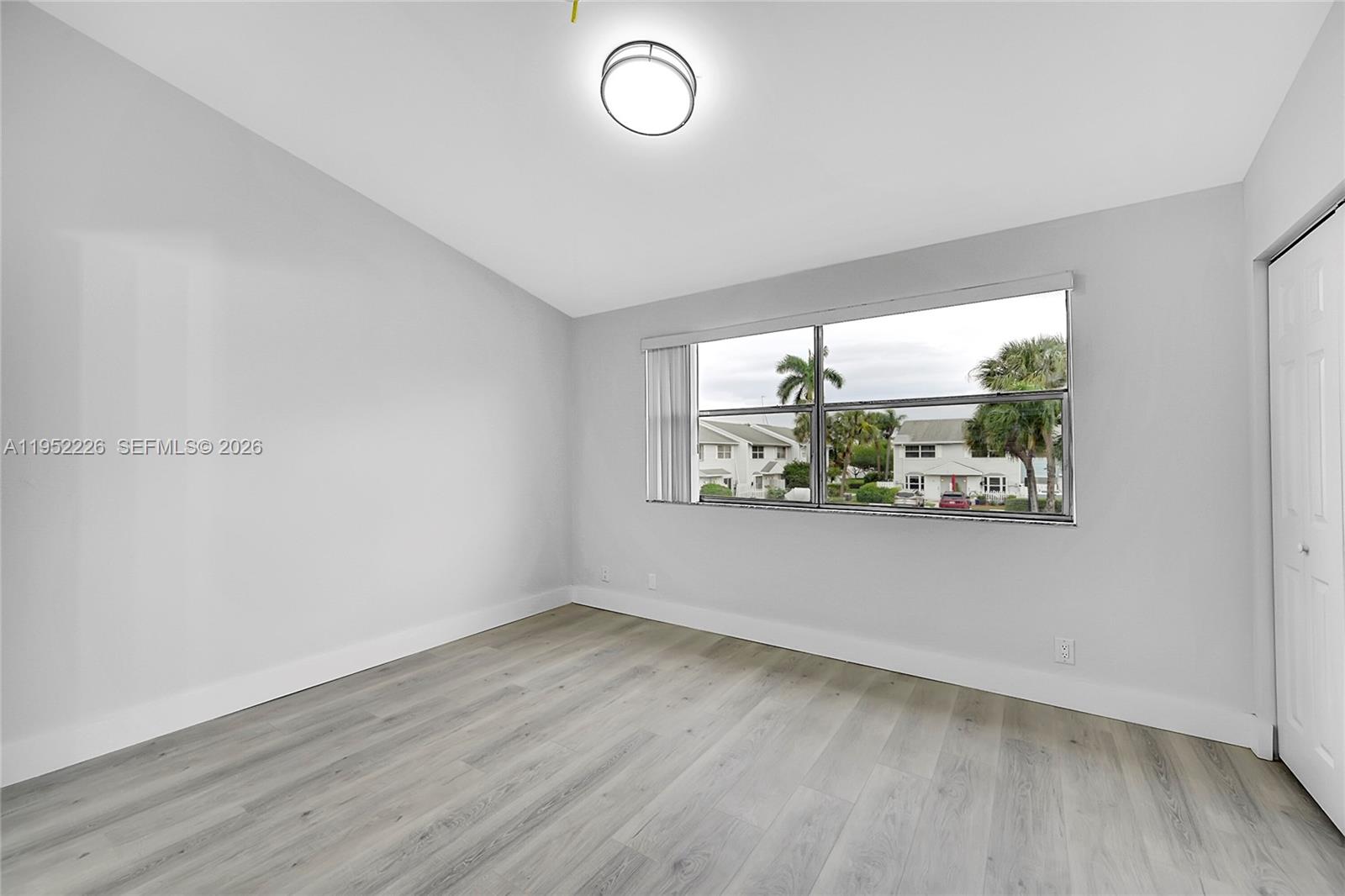 2699 Northeast 15th Street Pompano Beach, FL 33062 - Photo 14 of 29 an empty room with wooden floor and windows