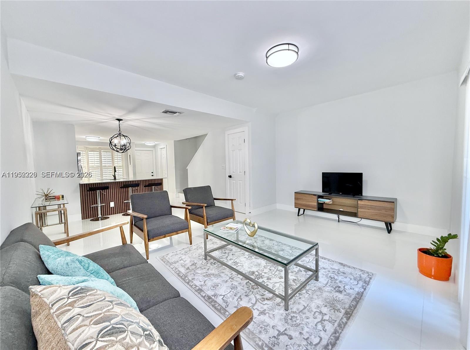 2699 Northeast 15th Street Pompano Beach, FL 33062 - Photo 4 of 29 a living room with furniture and a flat screen tv