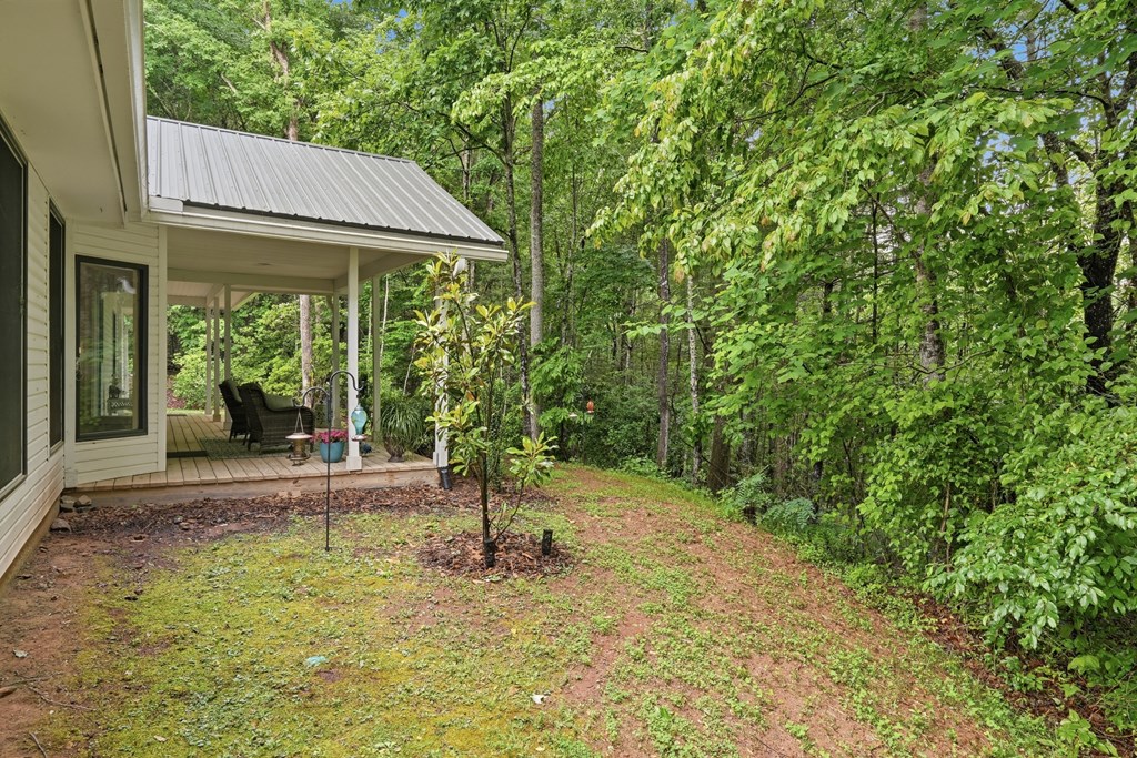 175 Crane Creek Road Young Harris, GA 30582 - Photo 32 of 40 a backyard of a house with table and chairs under an umbrella