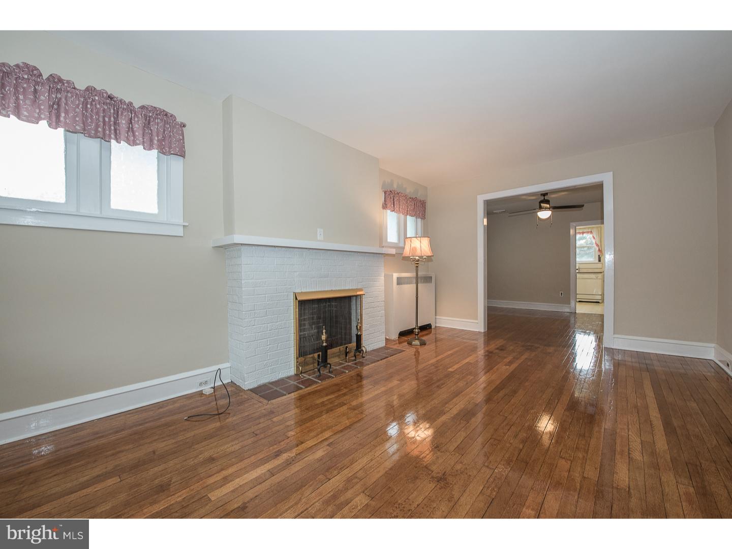 238 Strathmore Road Havertown, PA 19083 - Photo 7 of 25 a view of empty room with wooden floor and fireplace