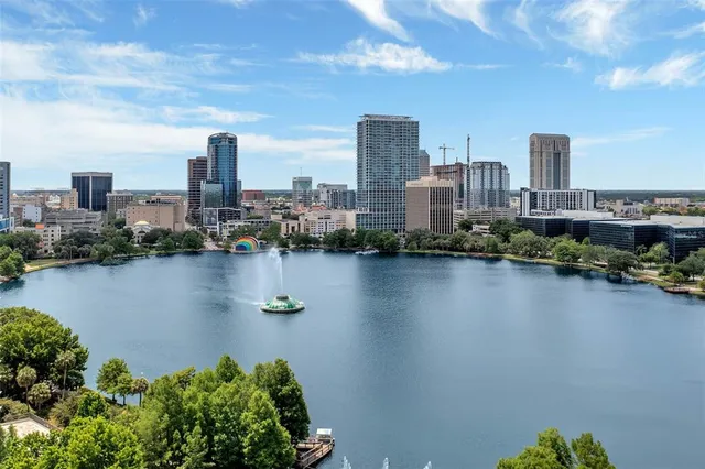 a backyard of a house with table and chairs potted plants and large tree
