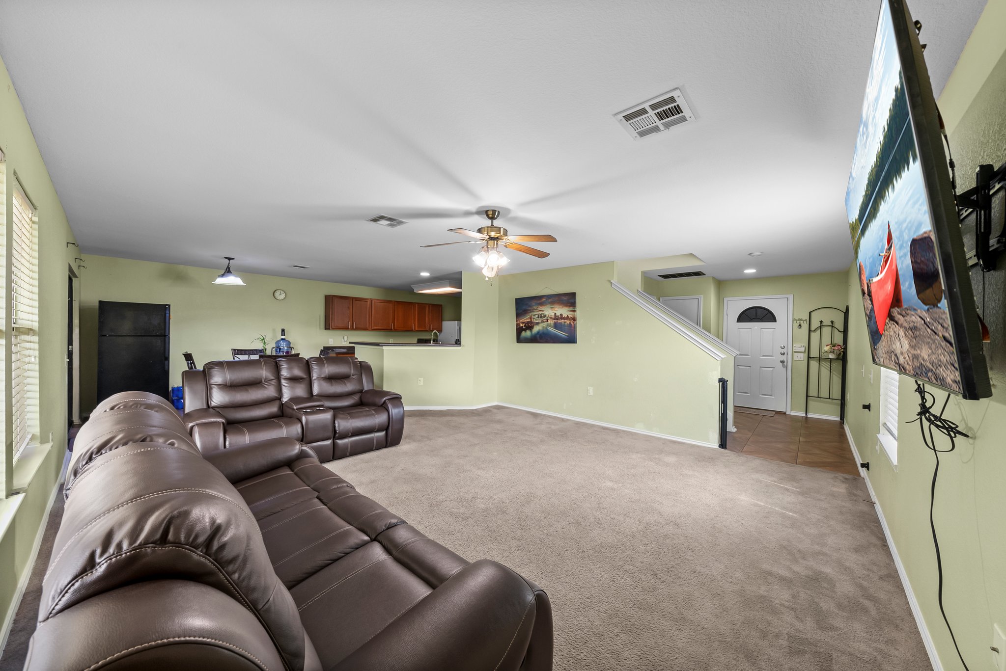 6829 Walkup Lane Austin, TX 78747 - Photo 5 of 18 A spacious, open-concept living area features warm carpet and a well-appointed kitchen nearby.